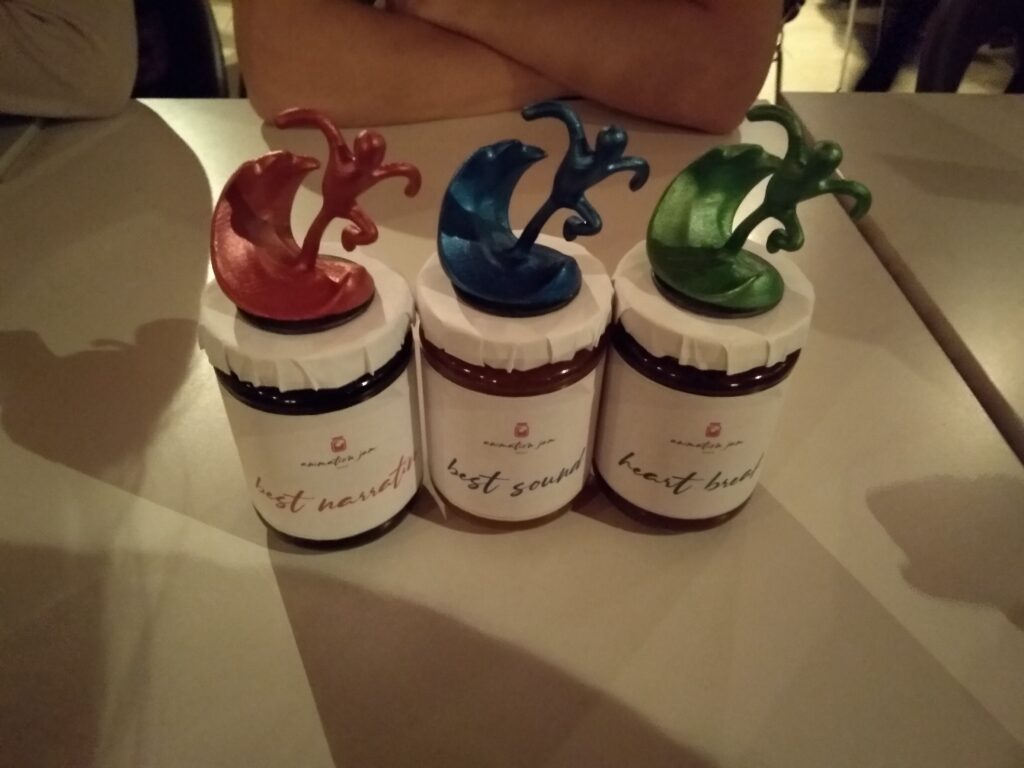 The three awards "Best narration" (red figure), "best sound" (blue figure), and "best heart break" (green figure).