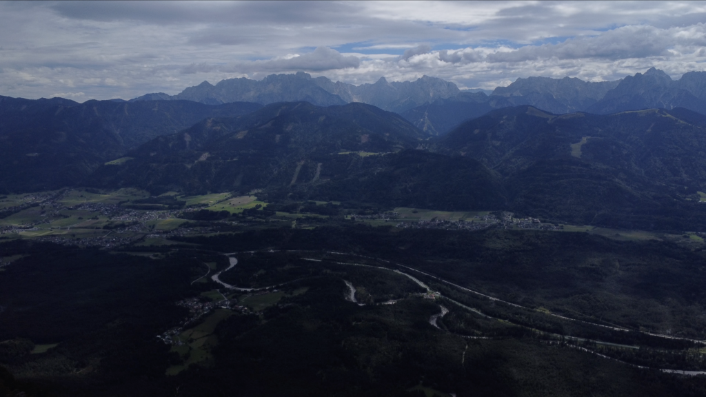 A view inside the valley with a river and mountains inside the background during summer times.